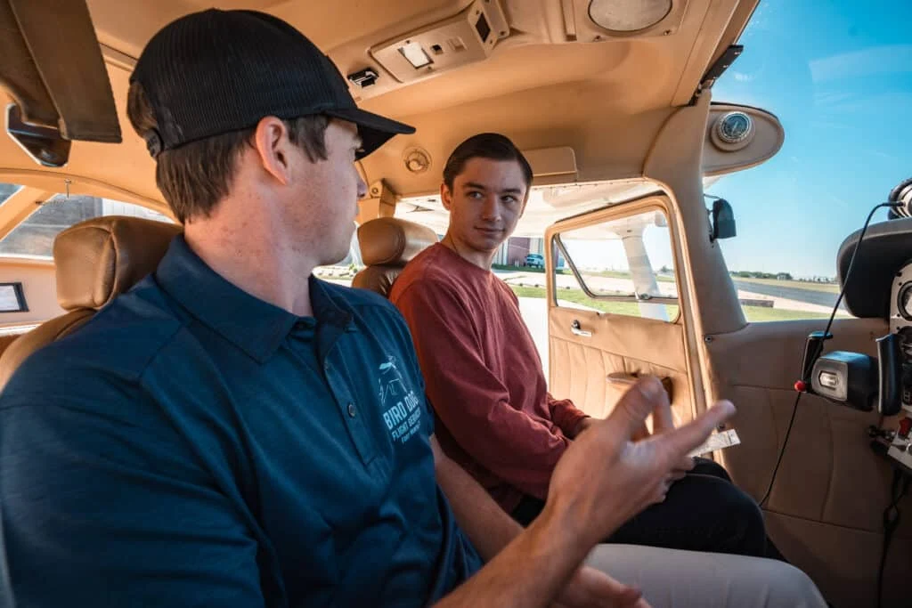 Flight instructor reviewing aeronautical charts and flight requirements with student
